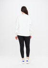 THE UPSIDE women's white Saturn Arrow Sweater is an organic cotton fleece jumper with a relaxed, oversized fit. It features a soft rib at the neckline, handcuffs and cuffs.