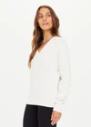 THE UPSIDE women's white Seymour Knit Sweater made with 100% organic cotton cable knit fabrication features a v-shaped neckline, ribbed cuffs, hem and neck, and embroidered arrow logo on back of neck.