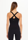 THE UPSIDE women's black, form-fitting Balance Seamless Lenny Tank is made from fabric with moisture control properties and is designed for a soft and supportive fit. This tank top features a scoop neck, cross back straps and shelf bra and bra cups for support.