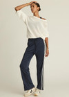 THE UPSIDE womens navy mid rise Celeste Pant made with slinky fabrication features a relaxed straight leg silhouette, elasticated waistband, drawcord, and white stripe down side seams.