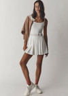 THE UPSIDE womens white scoop neck Peach Lucette panelled mini-dress made with Recycled Peach fabric features a pleated skirt with elastic waistband, built in shorts with pockets, and internal shelf bra.