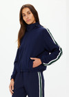 THE UPSIDE women's navy Mansi Dawson Run Jacket is made in a light and breathable recycled fabric, featuring colours of green and white. The run jacket is water resistant and is fitted with elasticated cuffs with inner sleeve gloves and invisible zip pockets and a large back pocket for storing purposes. Designed for golf.