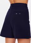 THE UPSIDE women's navy Mansi Wyatt Tailored Short is made from recycled fabric with moisture wicking properties. The long line shorts are fitted with front and back zip pockets for practicality. Designed for golf.