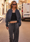 THE UPSIDE women's grey Carlotta Cropped Bomber Jacket is made from recycled fabric and is made for a cropped fit. This fully insulated jacket features an elastic hemband, ribbed cuffs and a detailed folded collar.