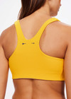 THE UPSIDE women's yellow Dunes Jade Racerback Bra is made from recycled textured rib fabrication with moisture wicking properties. The full coverage bra has a scooped T bar back, internal underbust elastic and removable cups . Designed for the gym.