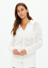 THE UPSIDE women's white Lavalliere Malia Knit Shirt is made from organic cotton. The long sleeve knit shirt features an open lace knit construction with bow knitted detailing and fitted with buttons and a ribbed collar. Designed leisure and recovery.