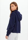 THE UPSIDE women's navy organic cotton Byron Embossed Logo Hoodie is designed for a relaxed boxy fit and features a tonal embossed horseshoe logo on the chest.