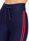 THE UPSIDE women's navy Oxford 25 inch Midi Pant is made from eco tech performance fabric. The gym leggings features red side stripes detailing. Designed for high impact workouts.