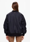 THE UPSIDE women's black Tribute Bomber Jacket is made from recycled fabric. The zip up jacket features water resistant coating and pockets. Designed for travel.