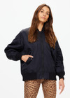 THE UPSIDE women's black Tribute Bomber Jacket is made from recycled fabric. The zip up jacket features water resistant coating and pockets. Designed for travel.