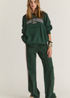 THE UPSIDE women's dark green Alumni Coolum Crew Neck Sweater is made from organic cotton and feature small side splits, front zip pocket and side pockets.