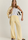 THE UPSIDE women's butter yellow Juliet Low Waist Trackpant is made from a slinky, lightweight fabric and feature side stripes, pockets and a split flared hem.