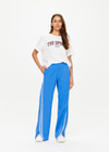 THE UPSIDE women's bright blue Juliet Low Waist Trackpant is made from a slinky, lightweight fabric and feature side stripes, pockets and a split flared hem.