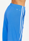 THE UPSIDE women's bright blue Juliet Low Waist Trackpant is made from a slinky, lightweight fabric and feature side stripes, pockets and a split flared hem.