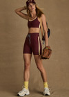 THE UPSIDE women's maroon Trail 6 inch Spin Short is made from soft, breathable fabric and features contrast butter yellow side stripe and an elastic waist.