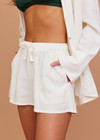 THE UPSIDE women's cream Hotel Du Cap Short is made from tencel linen blend. The elasticated waist short features drawstring. Designed for comfort and travel.
