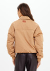 THE UPSIDE women's tan Carlotta Bomber Jacket is made from recycled fabric and made for a cropped fit. This fully insulated jacket features side seam pockets and metal arrow logo zipper.