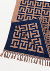 THE UPSIDE women's navy and tan cotton Ezra Beach Towel features a two-tone jacquard monogram design with knotted tassels at each end. Made for swim.