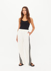 THE UPSIDE women’s cream Roma Pant is a true-to-size fit and features an elasticated waistband with drawcord, pockets and black and cream contrast stripes down sides. Perfect for everyday.