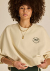 THE UPSIDE women's natural Molokai Paloma Crew is boxy fit with an embroidered green palm tree logo at front chest. Made for lifestyle.