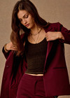THE UPSIDE women's maroon Mendoza Boyfriend Blazer is designed as a boyfriend style single breasted blazer with cream piping along side seams, tortoiseshell buttons and front welt pockets.