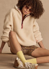 THE UPSIDE women's natural recycled polyester Harlow Fleece Pullover has a relaxed fit with a striped rib collar, contrast maroon stripes, and zip pockets. Made for lifestyle