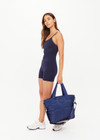 THE UPSIDE navy Barre Tote is fully insulated with multi internal pockets, a zip closure and an adjustable and removable shoulder strap. Made for everyday wear.