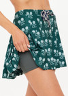 THE UPSIDE women's green Racquet Cadiz Pleated Skirt features built-in shorts with pockets and two tone drawcord with silver tennis racket charms. Made for tennis, golf & pickleball.