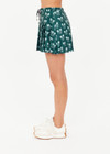 THE UPSIDE women's green Racquet Cadiz Pleated Skirt features built-in shorts with pockets and two tone drawcord with silver tennis racket charms. Made for tennis, golf & pickleball.