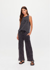 THE UPSIDE women's washed black Cosmic Wide Leg Shana Pant is a high waisted, wide-leg fit and features silver metal button snaps down leg that can be worn open.