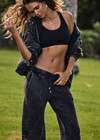 THE UPSIDE women's washed black Cosmic Wide Leg Shana Pant is a high waisted, wide-leg fit and features silver metal button snaps down leg that can be worn open.