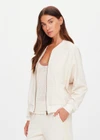 THE UPSIDE women's cream Navar Isabella Bomber Jacket is an oversized fit with raglan sleeves in our castilla "TU" design and features a front patch pocket, crafted from a knitted jacquard fabrication. Made for everyday wear.