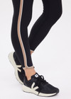 THE UPSIDE women's black recycled rib Rhythm 25inch Legging has a mid-rise fit and features cream and mocha binds along side seams. Made for yoga & pilates.