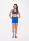 THE UPSIDE women's blue Montage Rory Scoop Knit Sports Bra is mid coverage, with a knitted scooped bra neckline, cream side pannels and a brown elasticated underbust. Made for yoga & pilates.