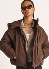 THE UPSIDE women's brown Mercer Hooded Puffer Jacket is fully lined and features invisible zip pockets with fleece lining, soft elasticated cuffs, a hood and is made from recycled fabric. Made for lifestyle.