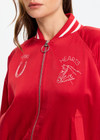 THE UPSIDE women's red 100% silk Two Hearts Silk Bomber Jacket is fully lined with cream and red stripes, welt pockets with triangle detail at top and bottom and an embroidered horse and horseshoe design. Made for lifestyle.