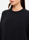 THE UPSIDE women's black organic cotton Paloma Crew is designed for an oversized fit and features dropped shoulders, ribbed trims and rhinestone logo detailing. Made for lifestyle.