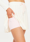 THE UPSIDE women’s cream recycled Cadiz Pleated Skirt is designed for a true to size fit and features a pleated design, built in inner short with pockets and drawcord detail. Made for tennis.
