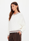 THE UPSIDE women's cream Millie V Neck Knit Sweater is designed for a relaxed fit and features a high v neckline and chocolate metallic stripes along cuffs, neckline and hem. Made for lifestyle.