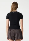 THE UPSIDE women's black Divina Isabella Baby Tee is designed for a soft and supportive fit in cotton modal fabrication and features a printed logo arrow in cream. Made for lifestyle.