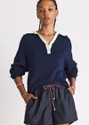 THE UPSIDE women's navy organic cotton Wonder Knit Polo is designed for a relaxed fit and features long sleeves with a contrast cream collar and placket. Made for lifestyle.