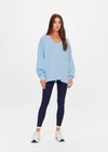 THE UPSIDE women's blue organic cotton Lou V Neck Sweater is an oversized fit and features dropped shoulders and a ribbed neckline and cuffs. Made for lifestyle.