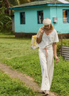 THE UPSIDE women's cream La Paz Malika Wide Leg Pant is a mid-rise straight leg fit and features an elasticated back waistband, an orange drawcord, an embroidered palm tree motif and side seam pockets. Made for lifestyle.