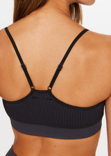 THE UPSIDE Ribbed Seamless Zahra Bra in Black is a mid-coverage bra with a T-bar back, adjustable elastic straps and removable cups.