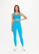 THE UPSIDE Peached 25inch High Midi Pant in Pool Blue is a recycled 25” midi length legging with a V shaped high-rise waistband and printed arrow logo at back.