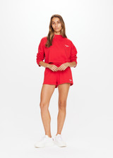 THE UPSIDE Courtsport Sabine Top in Chilli Red is a sustainable organic cotton cropped long sleeve top with ribbed mock neck, printed THE UPSIDE SPORT college logo in white and drop shoulders.