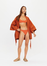 THE UPSIDE x THE BANYA orange rust robe is made from heavy organic cotton and features wide kimono-like sleeves, self-tie removable belt and welt pockets.