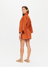 THE UPSIDE x THE BANYA orange rust robe is made from heavy organic cotton and features wide kimono-like sleeves, self-tie removable belt and welt pockets.