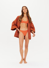 THE UPSIDE x THE BANYA orange rust Christy Bikini Pant is made from soft recycled ribbed fabrication and is fully lined with low coverage.
