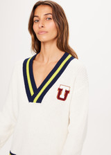 THE UPSIDE Varsity Josie Sweater in Bone is a sustainable organic cotton “V” neck knit sweater with contrasting coloured stripes, soft ribbed cuffs and hem and embroidered varsity TU patch at chest.